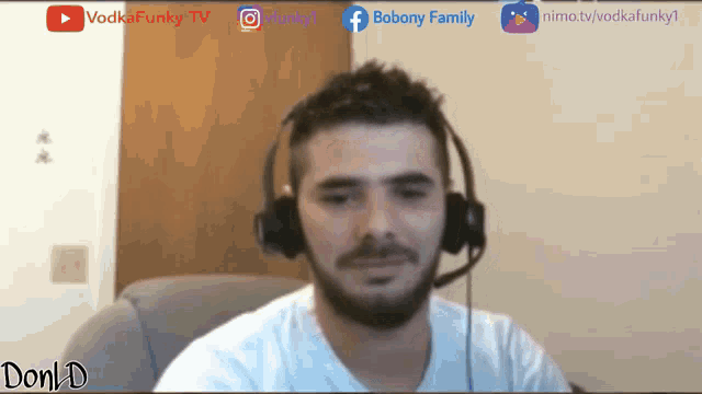 a man wearing headphones and a microphone is sitting in front of a screen that says don d
