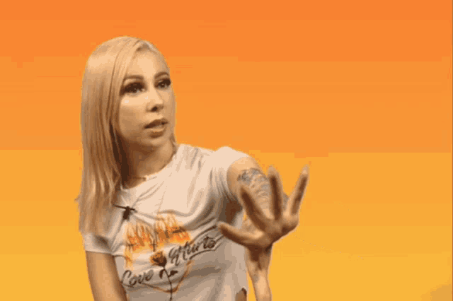 a woman with a tattoo on her arm is wearing a shirt that says love hurts