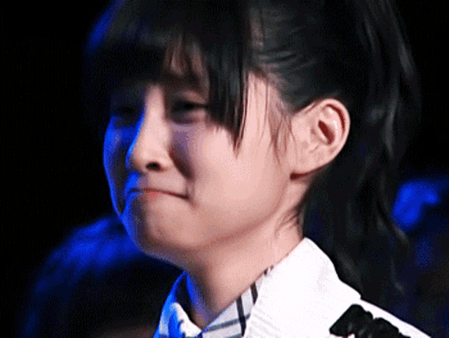 a close up of a young girl 's face with a ponytail