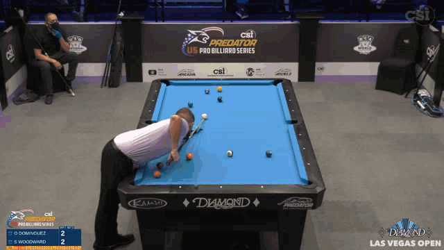 a man is playing pool in front of a pool table that says diamond on it