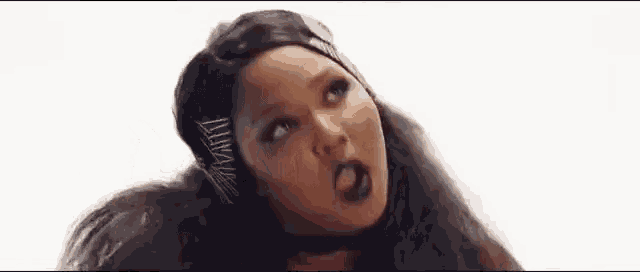 a close up of a woman 's face with long hair and black makeup .