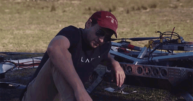 a man wearing a red hat and a black shirt that says ' la ' on it