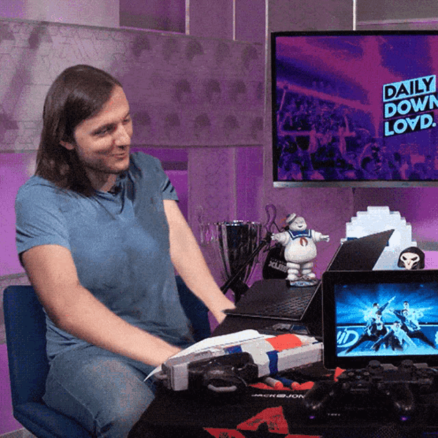 a man sits at a desk in front of a screen that says daily down lloyd