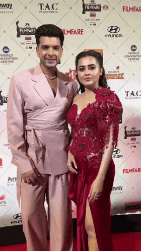 a man and a woman pose on a red carpet that says filmfare on it