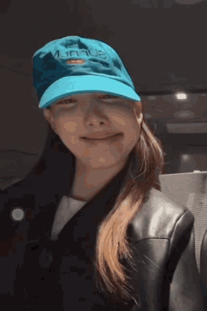 a woman wearing a blue hat with the word league embroidered on the front