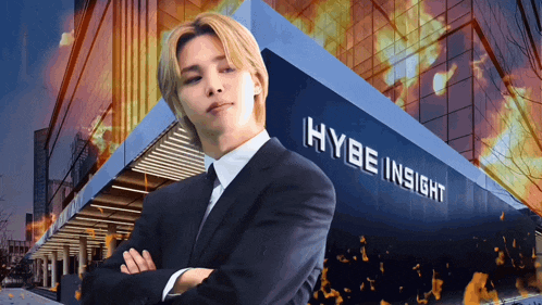a man in a suit stands in front of the hybe insight building