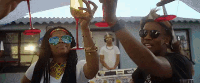 a woman wearing sunglasses is holding a glass of wine