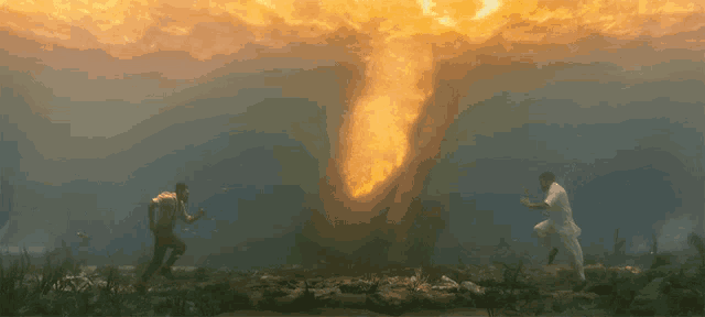 a man in a white shirt is standing in front of a large fireball in the ocean