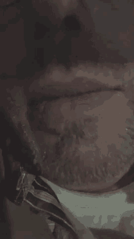 a close up of a man 's face with a tie around his neck