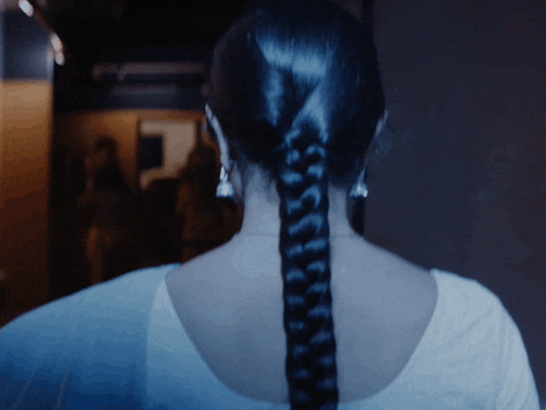 a woman with a braided ponytail and earrings
