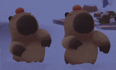two stuffed animals with a pumpkin on their hats are dancing in the snow