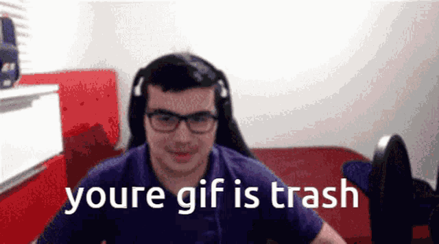 a man with glasses and headphones says " youre gif is trash " in front of a red couch