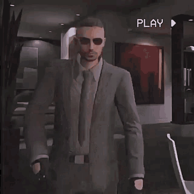 a man in a suit and tie is standing in a room with the word play on the bottom