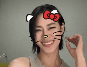a woman wearing a hello kitty face mask is smiling
