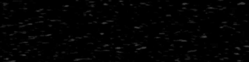 it looks like snow is falling on a black background .