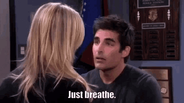 a man and a woman are looking at each other and the woman is saying `` just breathe '' .