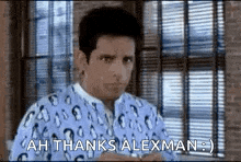 a man in a leopard print shirt is standing in front of a window and saying `` ah thanks alexman '' .
