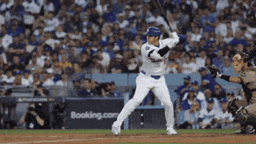 a baseball player getting ready to swing at a ball with a booking.com ad in the background
