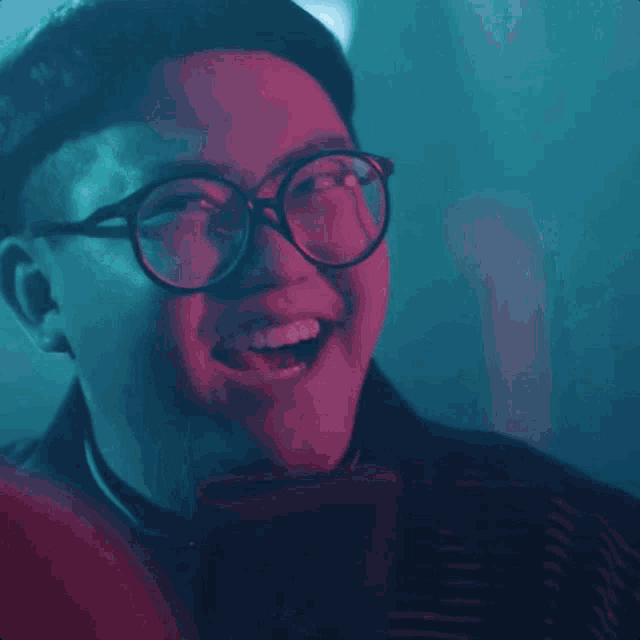 a man with glasses is looking at his phone