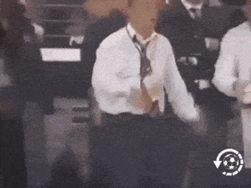 a man in a white shirt and tie is dancing in front of a crowd .