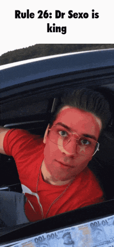 a man with red paint on his face is sitting in a car with rule 26 dr sexo is king written below him
