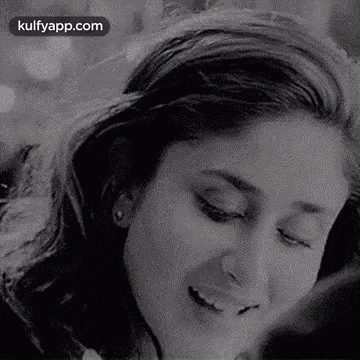 a close up of a woman 's face with her eyes closed and smiling .