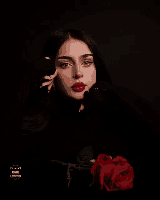 a woman in a black sweater holds a red rose
