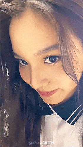 a close up of a woman 's face with aymgreen written on the bottom right