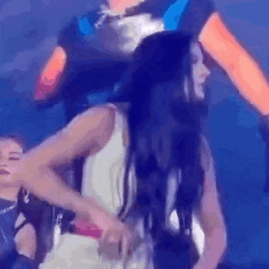 a man is carrying a woman on his shoulders while they are dancing on stage .