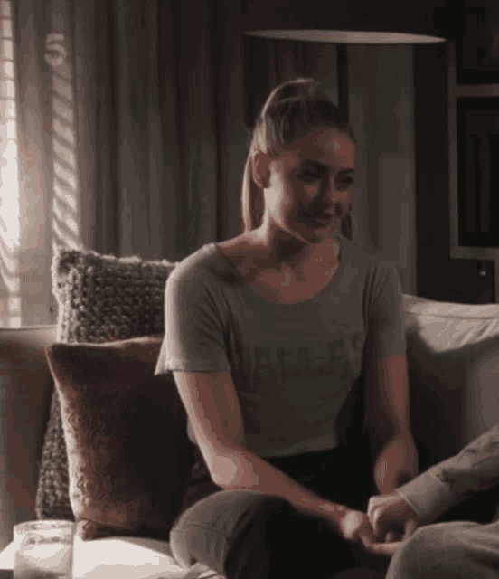 a woman sitting on a couch wearing a shirt that says dallas