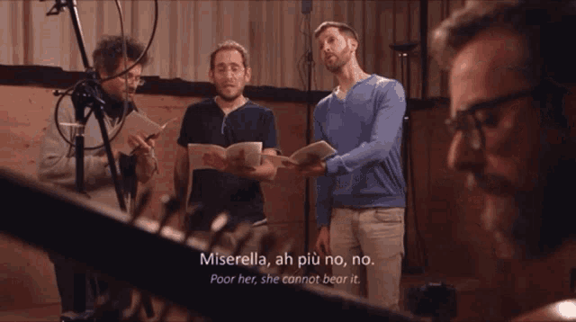 a group of men singing in front of microphones with the words miserella ah più no no poor her she cannot bear it