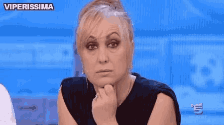 a woman is sitting in front of a blue screen with the words viperissima above her