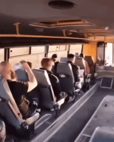 a group of people are sitting on a bus looking out the windows