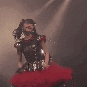 a girl in a red tutu is dancing on stage .