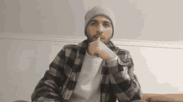 a man wearing a plaid shirt and a beanie