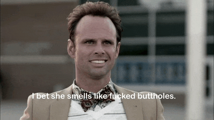 a man in a suit and tie smiles with the words i bet she smells like fucked buttholes below him