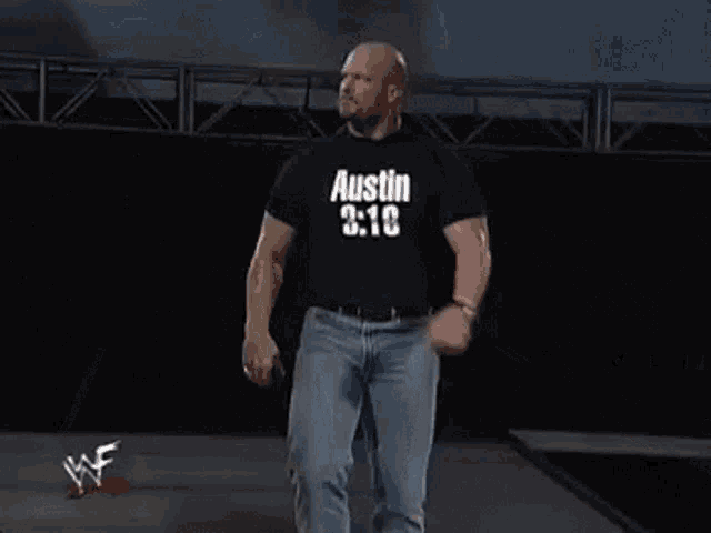 a man wearing a black shirt that says austin 3:16 walks down a stage