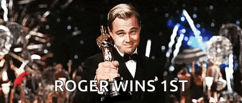 a man in a tuxedo is holding an oscar statue with the words " roger wins 1st " below him
