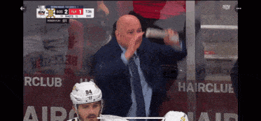 a hockey game is being played in front of a hair club