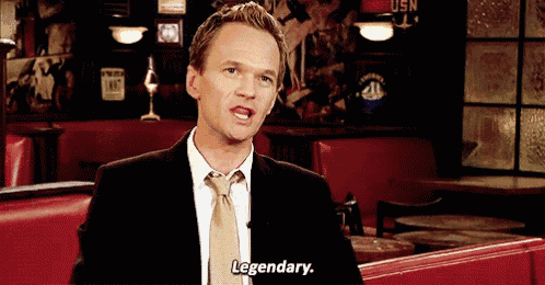 a man in a suit and tie is saying legendary in a restaurant