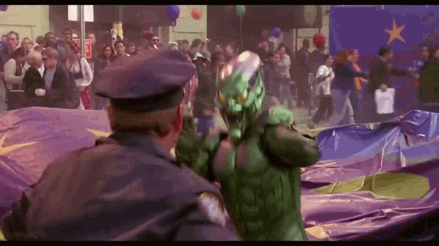 a man in a green superhero costume stands next to a police officer in front of a crowd