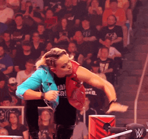 a woman in a wrestling ring is wearing a shirt that says ' i am a wrestler '