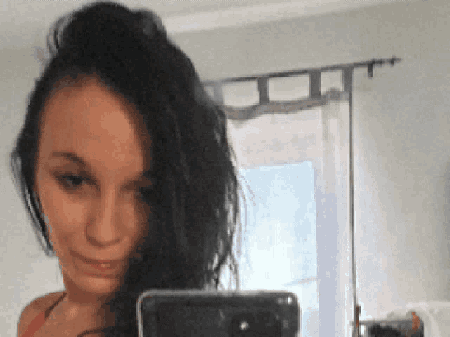 a woman is taking a selfie with her cell phone