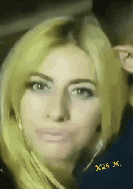 a close up of a woman 's face with the name nika m. on the bottom right