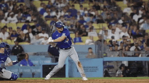 a baseball player in a blue uniform is swinging his bat at a ball