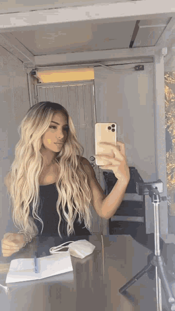 a woman taking a selfie in front of a mirror with her phone