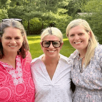 three women are posing for a picture and one of them is wearing sunglasses