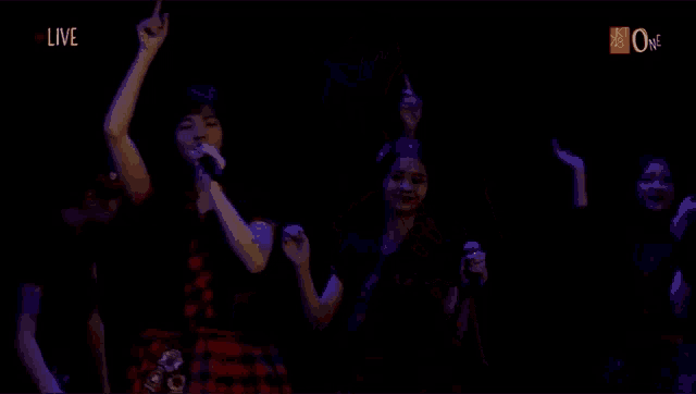 a woman singing into a microphone with the word live on the bottom right