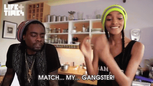 a man and a woman are dancing in a kitchen and the woman is saying match my gangster