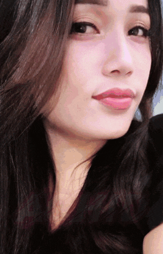 a close up of a woman 's face with dark hair and pink lips